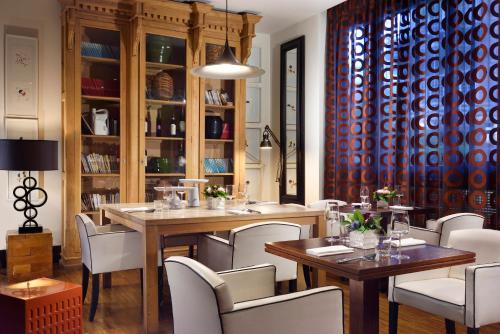 a dining room with tables and white chairs at Hotel Pulitzer in Rome