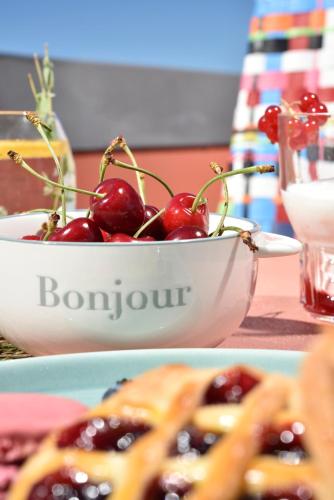 two plates of food with cherries in a bowl at Hotel Pulitzer in Rome