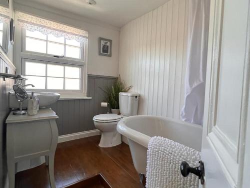 a bathroom with a tub and a toilet and a sink at Bridewell Cottage in the heart of Tenterden - Pass The Keys in Tenterden