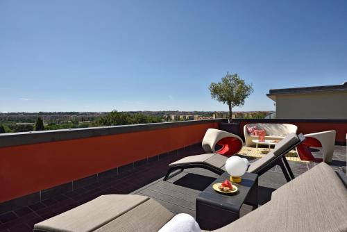 a balcony with a couch and chairs on a roof at Hotel Pulitzer in Rome
