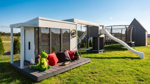 a playground with a slide in a field at Loox Ostrovo- Boutique House-noclegi nad morzem in Ostrowo