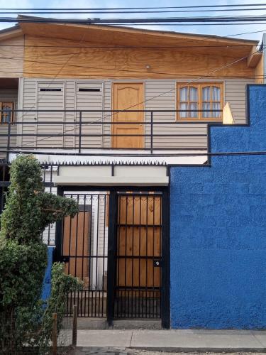 a blue building with a gate and a blue wall at Departamento amplio y cómodo in Iquique