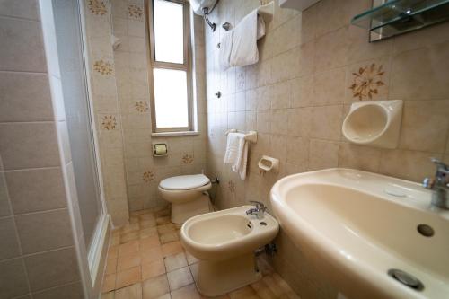a bathroom with a toilet and a sink and a tub at Hotel San Pietro in Letojanni