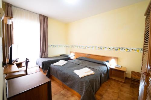 a hotel room with two beds and a window at Hotel San Pietro in Letojanni