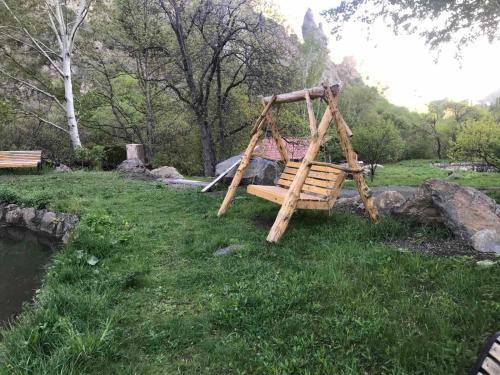 a wooden swing set in a park next to a river at Old Jermuk 