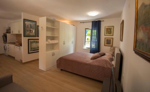 a small bedroom with a bed and a window at Studio apartman ROZA in Ston