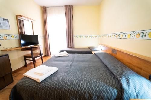 a bedroom with a bed with two towels on it at Hotel San Pietro in Letojanni