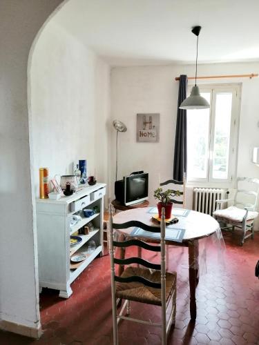 un salon avec une table et une télévision dans l'établissement Appartement charmant à La Seyne-sur-Mer 44 m² avec terrasse, à La Seyne-sur-Mer