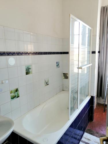 La salle de bains est pourvue d'une baignoire et d'une douche en verre. dans l'établissement Appartement charmant à La Seyne-sur-Mer 44 m² avec terrasse, à La Seyne-sur-Mer