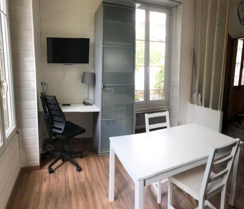 a room with a white table and a desk at Le Coeur, Studio central refait à neuf, au calme in Besançon