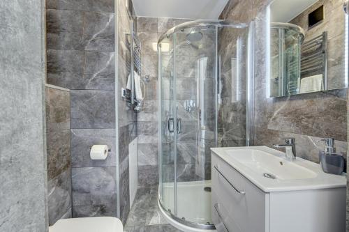 a bathroom with a shower and a toilet and a sink at Apartamenty 111 in Pobierowo
