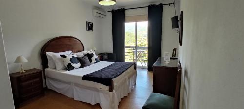a bedroom with a large bed and a window at Residencial Do Rita em Rio Caldo in Geres