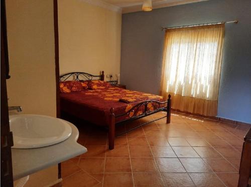 Un dormitorio con una cama, una bañera y un lavabo. en Dar Elbiad A1, duplex très mignon, en Ifargane