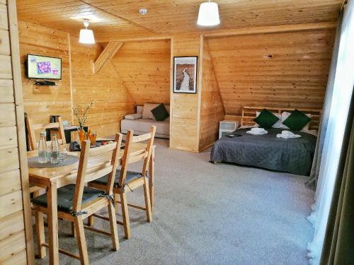 a room with a bed and a table in a cabin at Pokoje i Domki Na Szlaku in Polanica-Zdrój