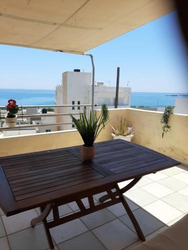 a wooden table on a balcony with a view of the ocean at Comfy Apartment near the Sea in Ierápetra