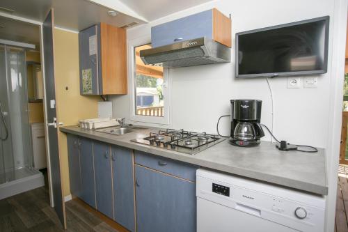 a kitchen with a sink and a stove top oven at Camping du Lac in Foix