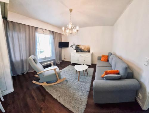 uma sala de estar com um sofá e uma cadeira em Cozy house with sauna 10 min walk to Santa Claus Village em Rovaniemi