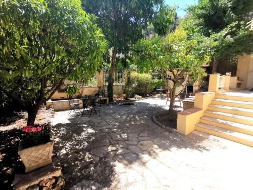 un patio con árboles, mesa y sillas en Chambre privée luxueuse Villa Monte 0ropa en Niza