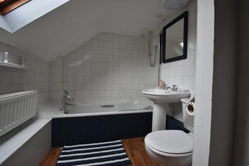 a bathroom with a sink and a toilet and a tub at Yewtree Cottage - 'The Art House' and Garden in Hunters Quay