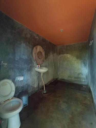 a bathroom with a toilet and a sink at Keramas Surf Hostel in Keramas