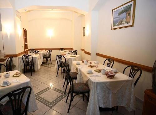 una sala da pranzo con tavoli e sedie con tovaglia bianca di Albergo delle Rose a Bagnara Calabra