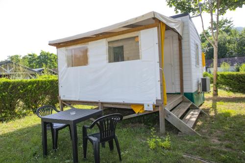 a tiny house with a table and two chairs at Camping du Lac in Foix