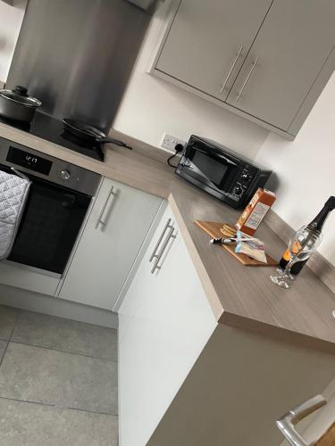 a kitchen with a counter with a microwave and a bottle of wine at Ancaster Apartments in Brumby