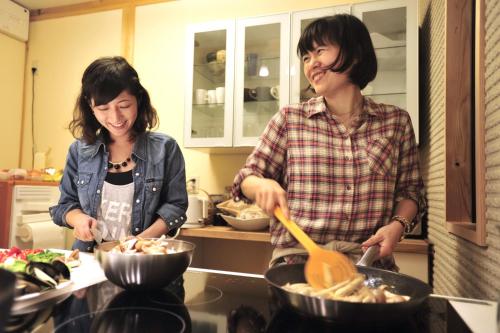 a man and woman preparing food in a kitchen at Miyama KAYA Villa in Nantan city