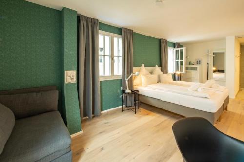 a bedroom with a large bed and a couch at Gästehaus am Schlossplatz, Z. 2 in Meersburg