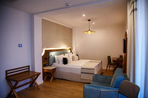 a hotel room with a bed and a table and chairs at New Egreta Resort in Dunavăţu de Jos