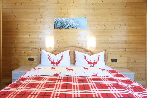 a bedroom with a bed with red antlers on it at Gasthof zur Post - Hauserwirt in Sankt Jakob in Haus