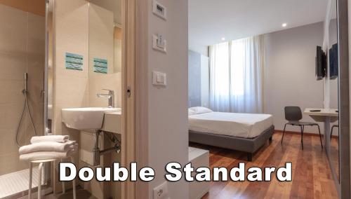 a bathroom with a sink and a bed in a room at Hotel Boston in Montecatini Terme