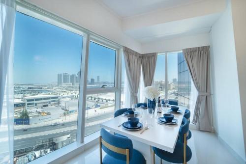 a dining room with a table and chairs and large windows at Blue dream apartment with Harbour view in Marina in Dubai