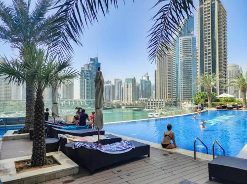 a swimming pool with a city skyline in the background at Blue dream apartment with Harbour view in Marina in Dubai