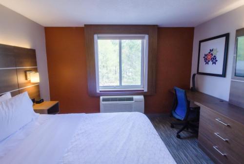 a hotel room with a bed and a window at Holiday Inn Express & Suites - Lincoln East - White Mountains by IHG in Lincoln