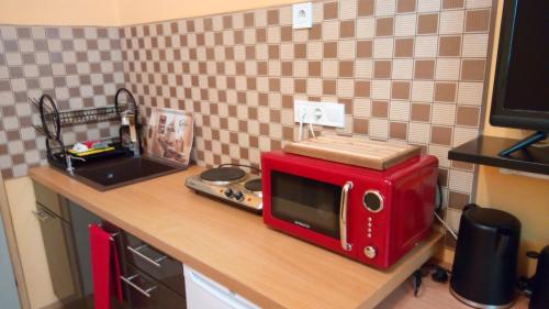 un microondas rojo sentado en una encimera en una cocina en City Lights Apartman, en Keszthely