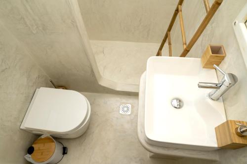 a bathroom with a white sink and a toilet at Argo-studios in Kinion