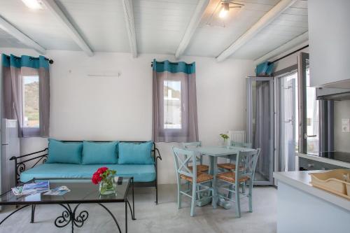 a living room with a blue couch and a table at Ianthi Boutique Guesthouses Skyros in Skiros