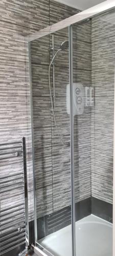 a shower with a glass door in a bathroom at The Golf Studio Woodhall Spa in Woodhall Spa