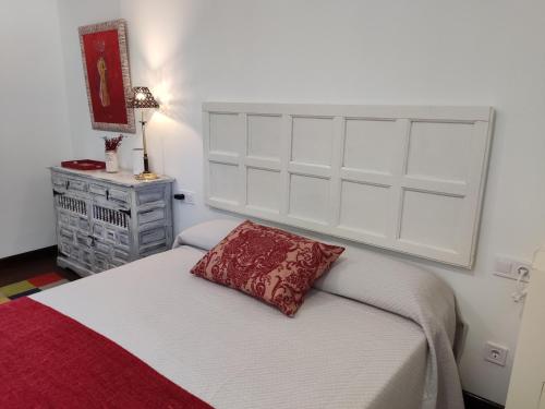 a bedroom with a bed with a red pillow on it at EL MOTIVO in Cercedilla