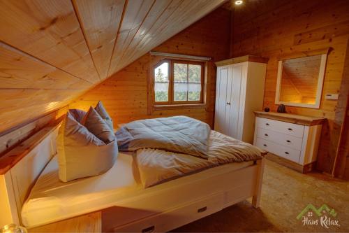 una camera con un letto in una cabina di legno di haus-relax - no business b00king - no fitters 