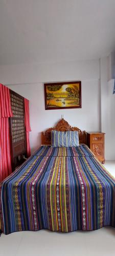a bedroom with a large bed with a colorful comforter at 6th Balcony in Baguio