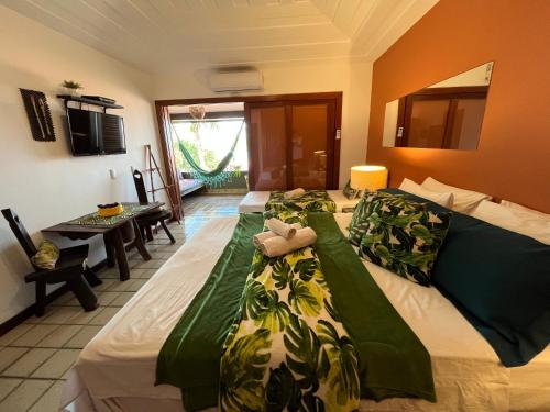 um quarto com duas camas com cobertores verdes e brancos em Casa de CINEMA 3 suites, 50m da Praia da Ferradura em Búzios