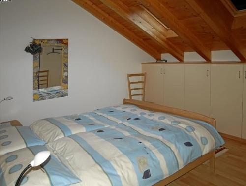 1 dormitorio con cama y espejo en la pared en Appartamento N. 6 Casa Betulla, en Sonogno