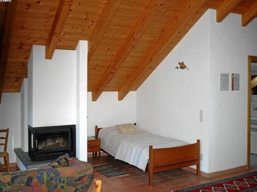 a bedroom with a bed and a fireplace at Appartamento N. 6 Casa Betulla in Sonogno