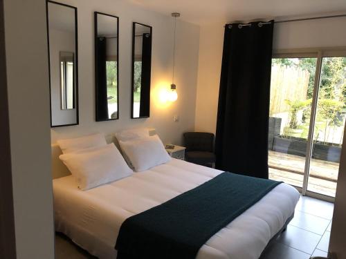 a bedroom with a bed with two pillows and a window at Villa COSA Spa privatif, Gîte proche Sarlat in Vitrac