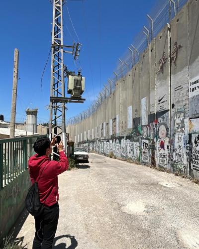 a man taking a picture of a wall at Bethlehem City Hostel in Bethlehem