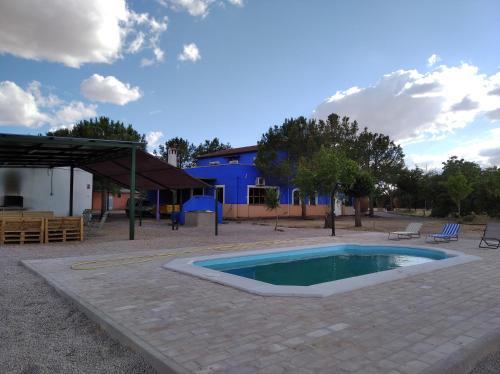 uma pequena piscina num pátio com um edifício em La Venta de las Estrellas Casas Rurales em Valdepeñas