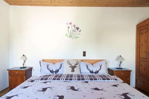 a bedroom with a bed with antlers on the wall at Gasthof zur Post - Hauserwirt in Sankt Jakob in Haus