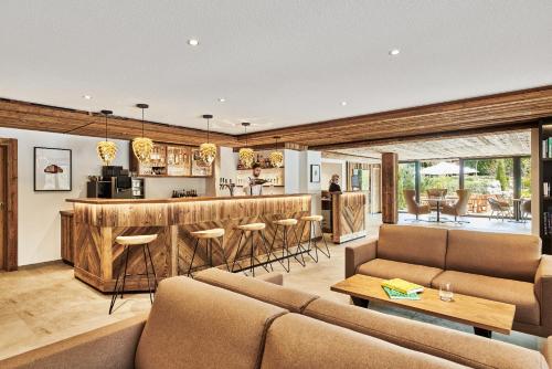 a living room with a couch and a bar at ADLER HÄUSERN Gourmet & Spa Hotel in Häusern